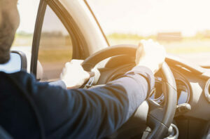 A chauffeur from German Limousines vigorously holding a steering wheel.