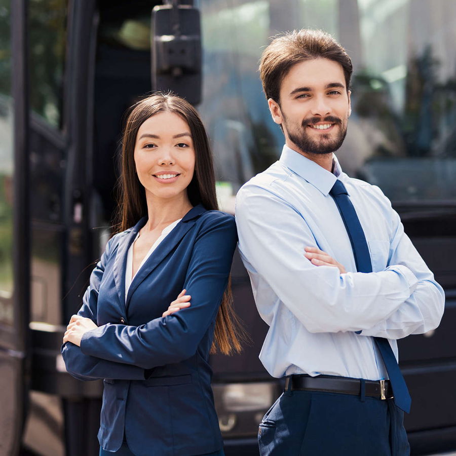 Eine junge Frau und ein Mann mit Bart, die beide sehr gut gekleidet sind, lächeln den Betrachter an. Sie kümmern sich um die Einsatzgebiete des Limousinenservice Frankfurt.